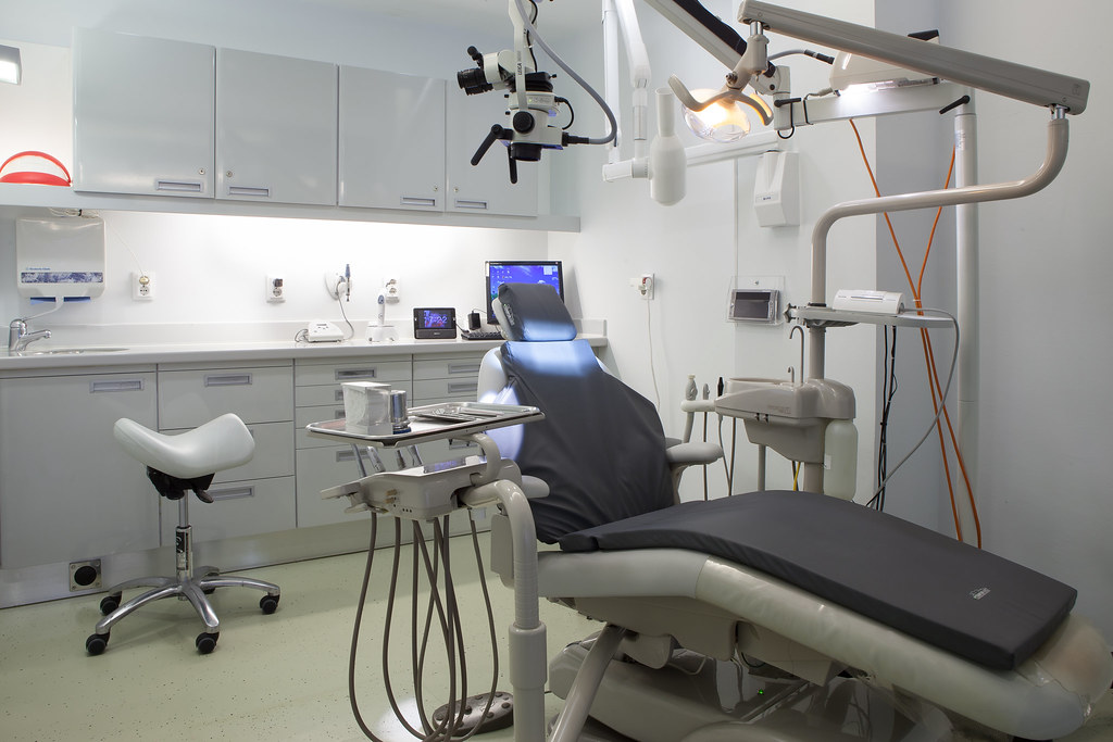 Sala de tratamentos dentários com cadeira e equipamento clínico